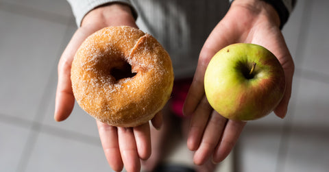 donut in one hand apple in the other